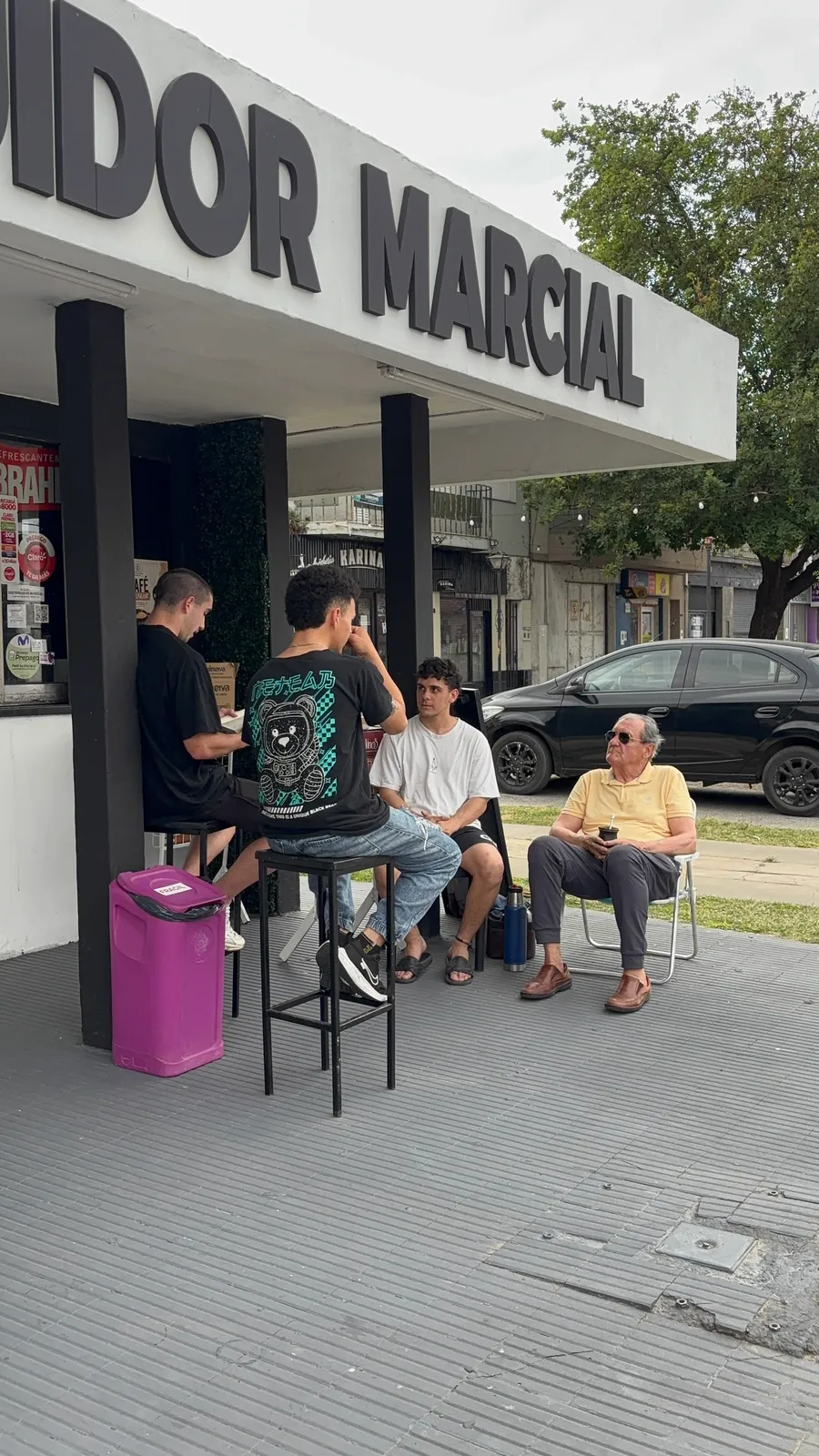 Lectores sentados bajo el cartel de Distribuidor Marcial